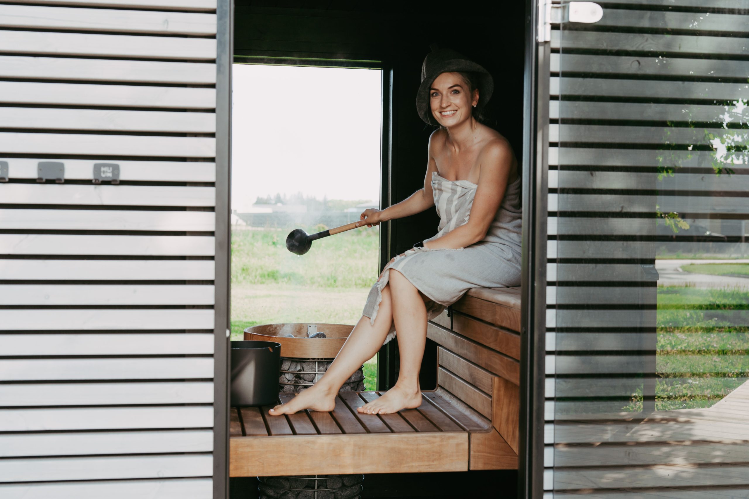 Femme détente sauna avec serviette et chapeau