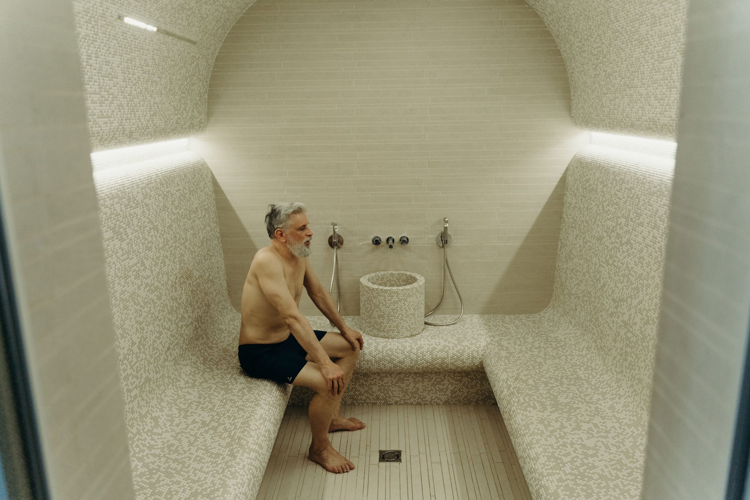 Homme senior relaxé dans sauna moderne et calme