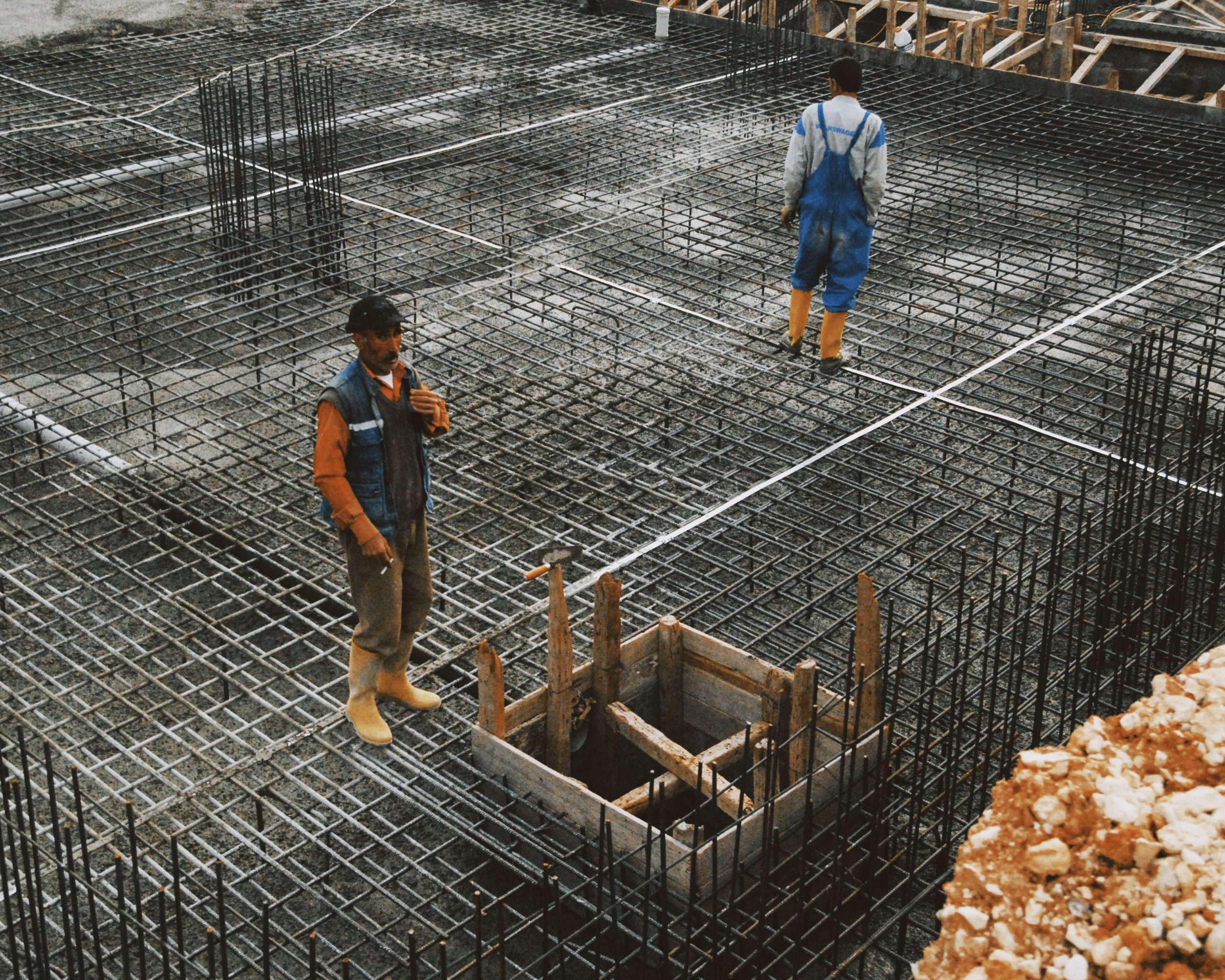 Ouvriers préparant les armatures acier pour fondation béton