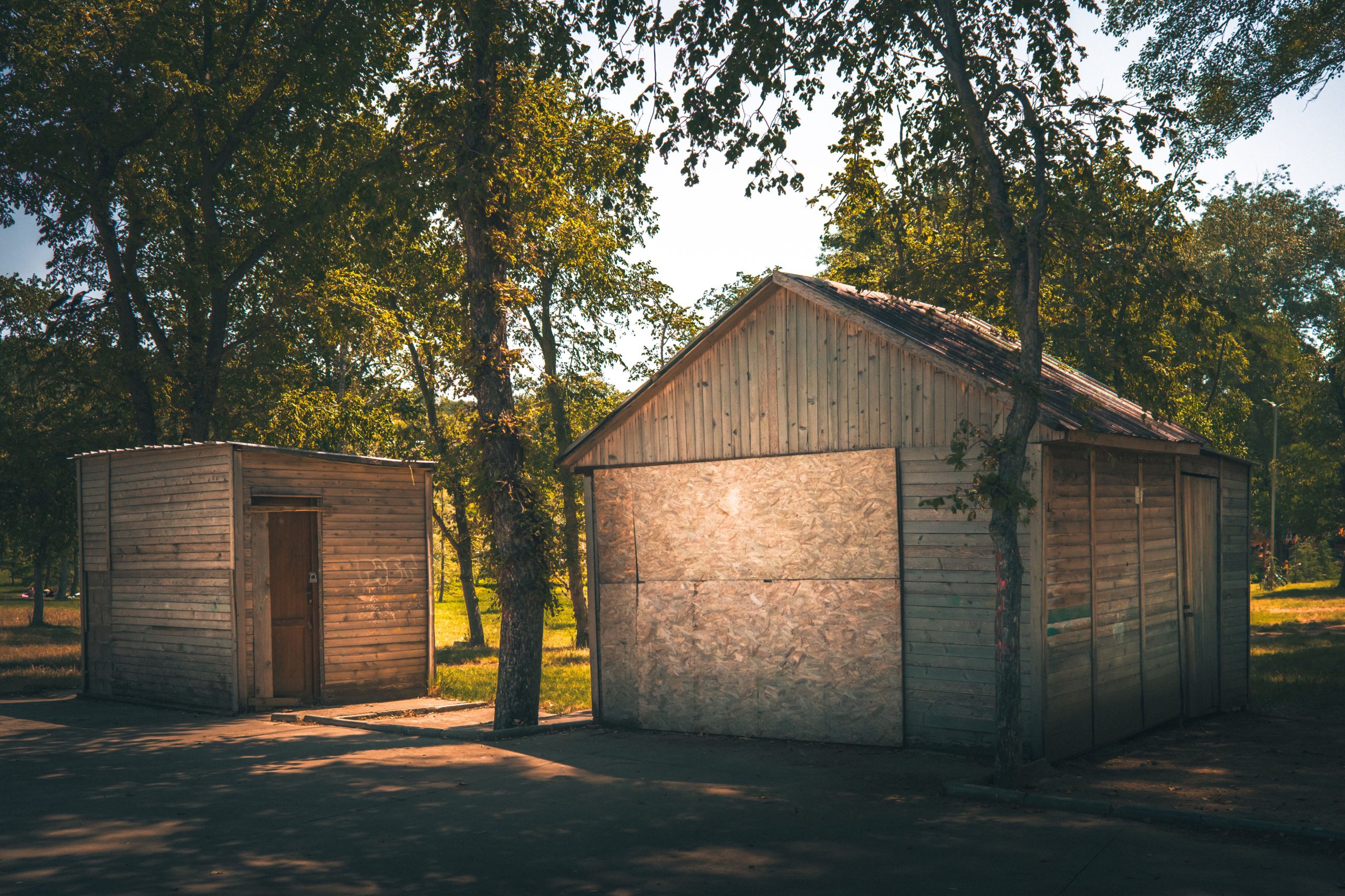 Deux cabanes rustic en bois ensoleillé et verdure.