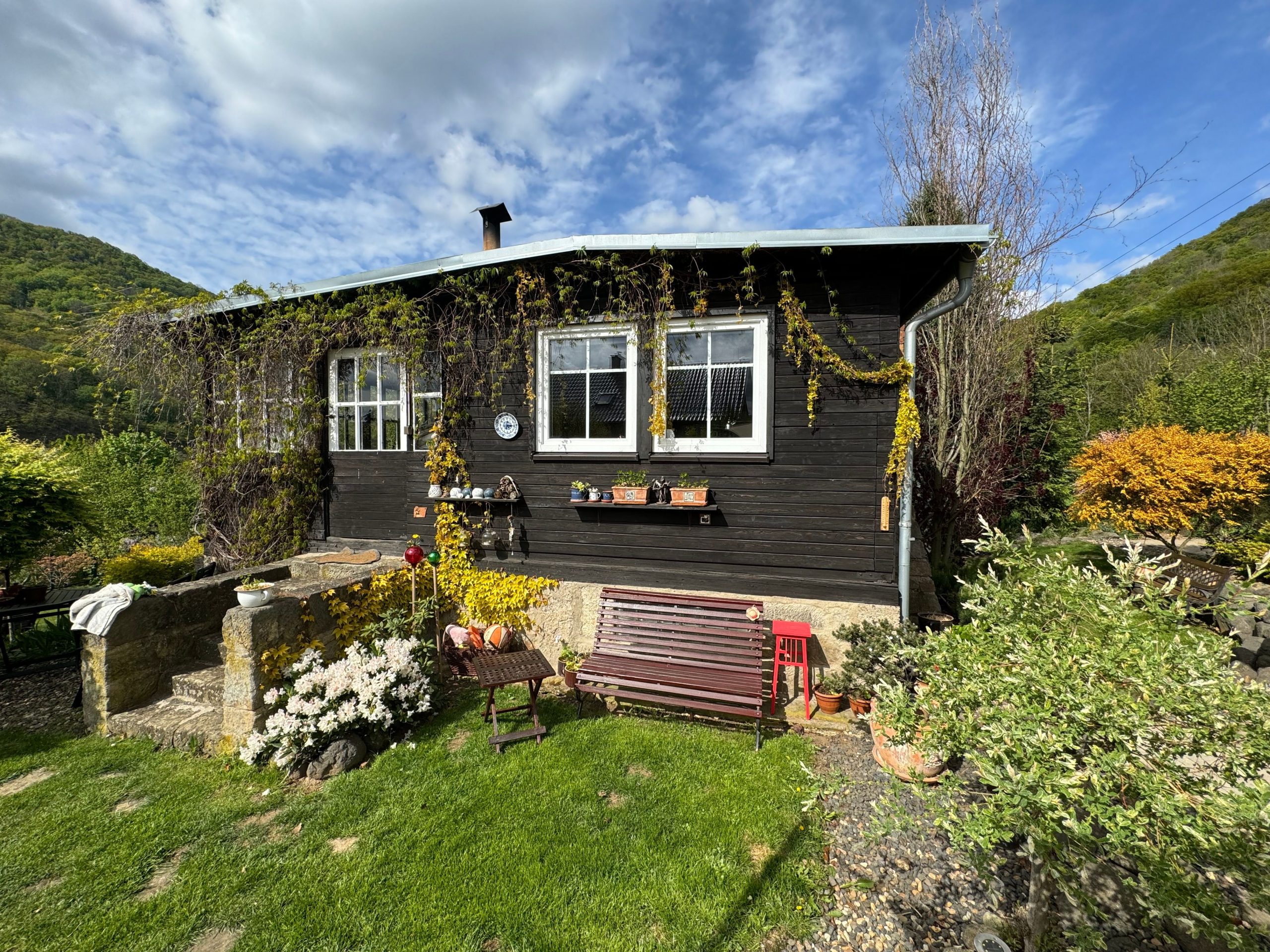 Cabane en bois pittoresque dans un jardin fleuri